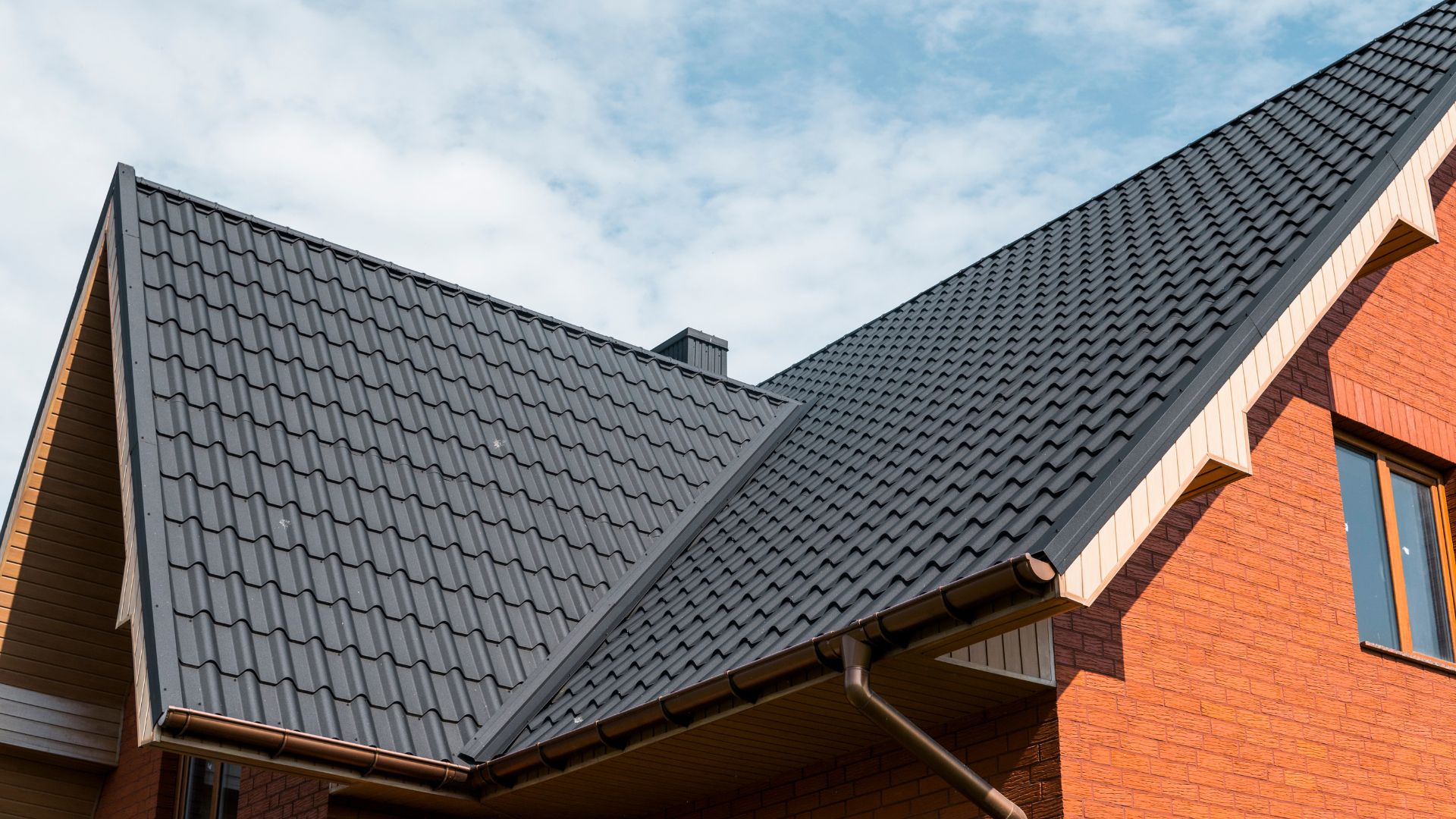 A red brick house with a black roof
